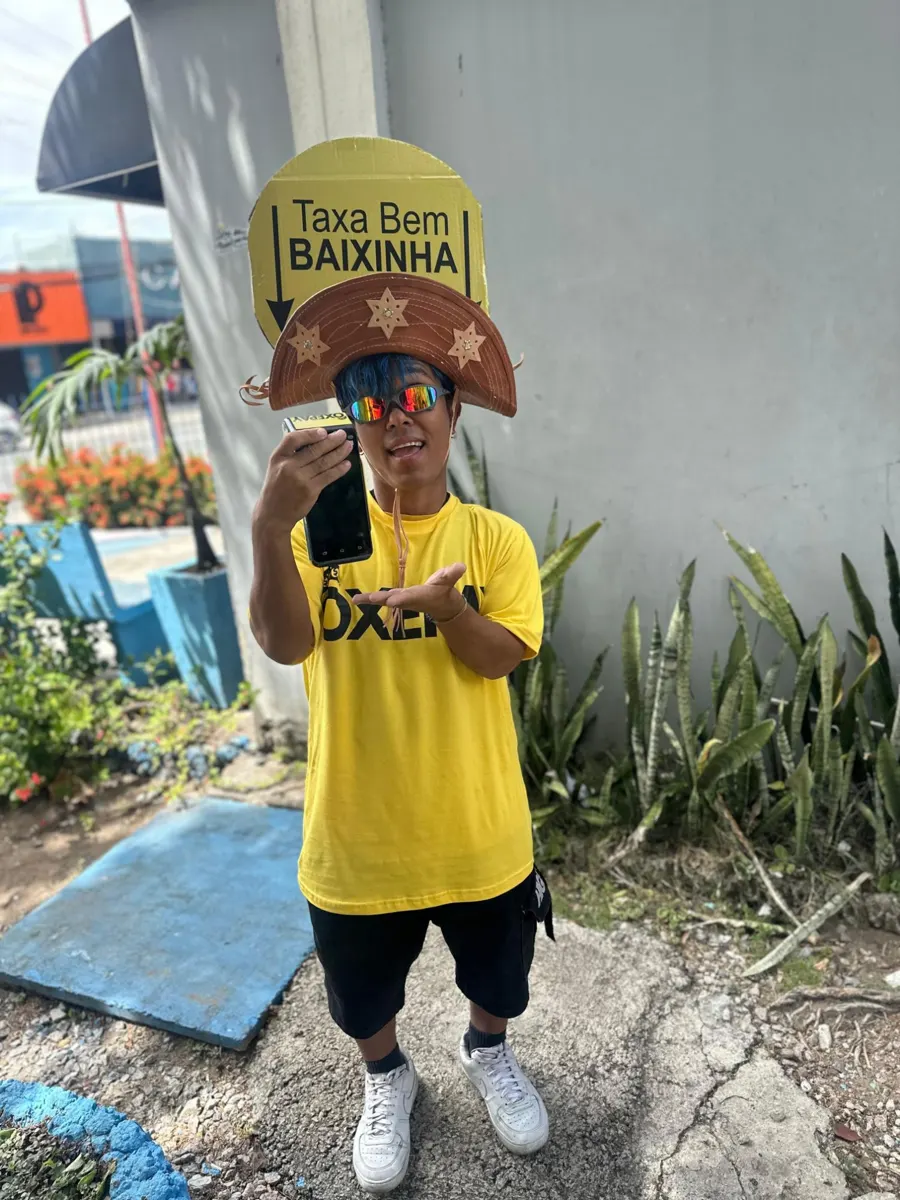 Personagem OxePay com chapéu de couro mostrando o celular